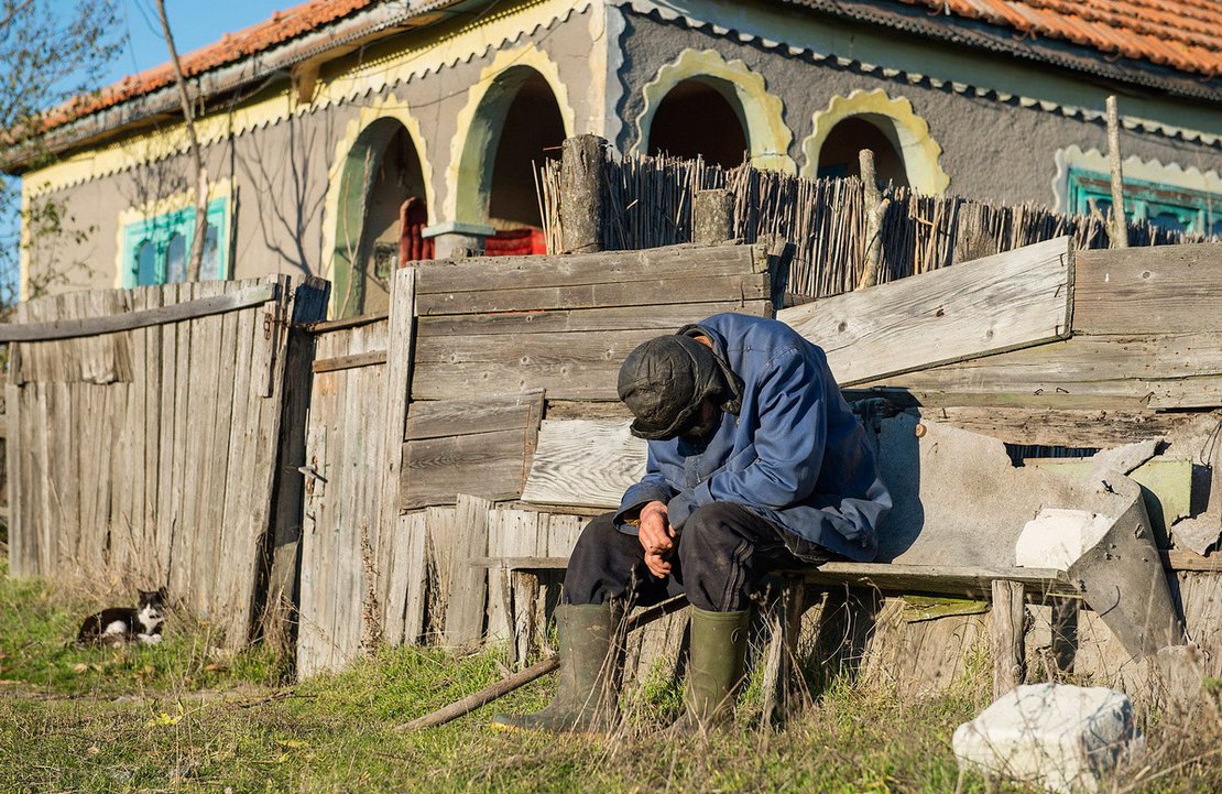 An old man rests in front of his house in Sfistofca, the Danube Delta, Romania